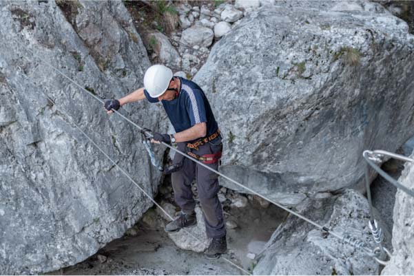 Homme sur un pont de singe dans une via ferrata