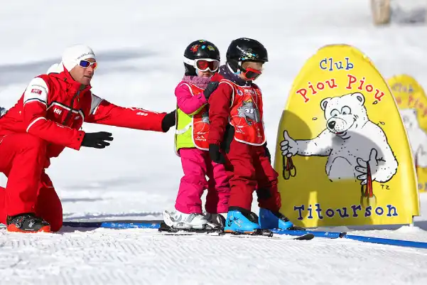 Enfants avec un moniteur sur un espace Piou-Piou de l'ESF