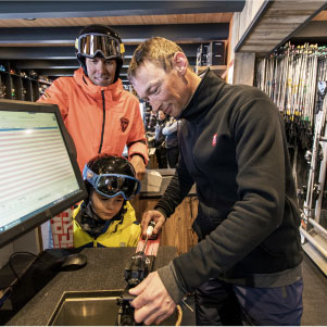 Père qui loue une paire de ski à son enfant